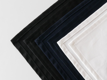 Lade das Bild in den Galerie-Viewer, In weiß, schwarz und marineblau sind drei Weinkrawatten zu sehen, die mit einem Kuvertsaum edel umgenäht sind. Hochwertiger Baumwollköper.